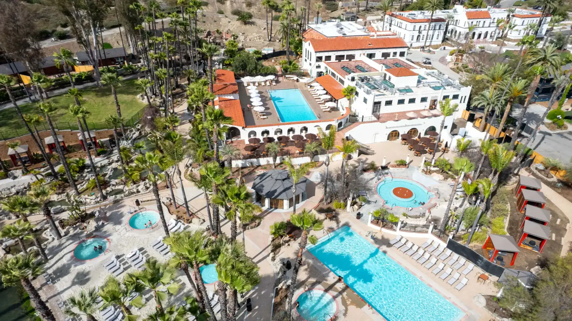 Aerial view of Murrieta Hot Springs Resort with pools and lush greenery.