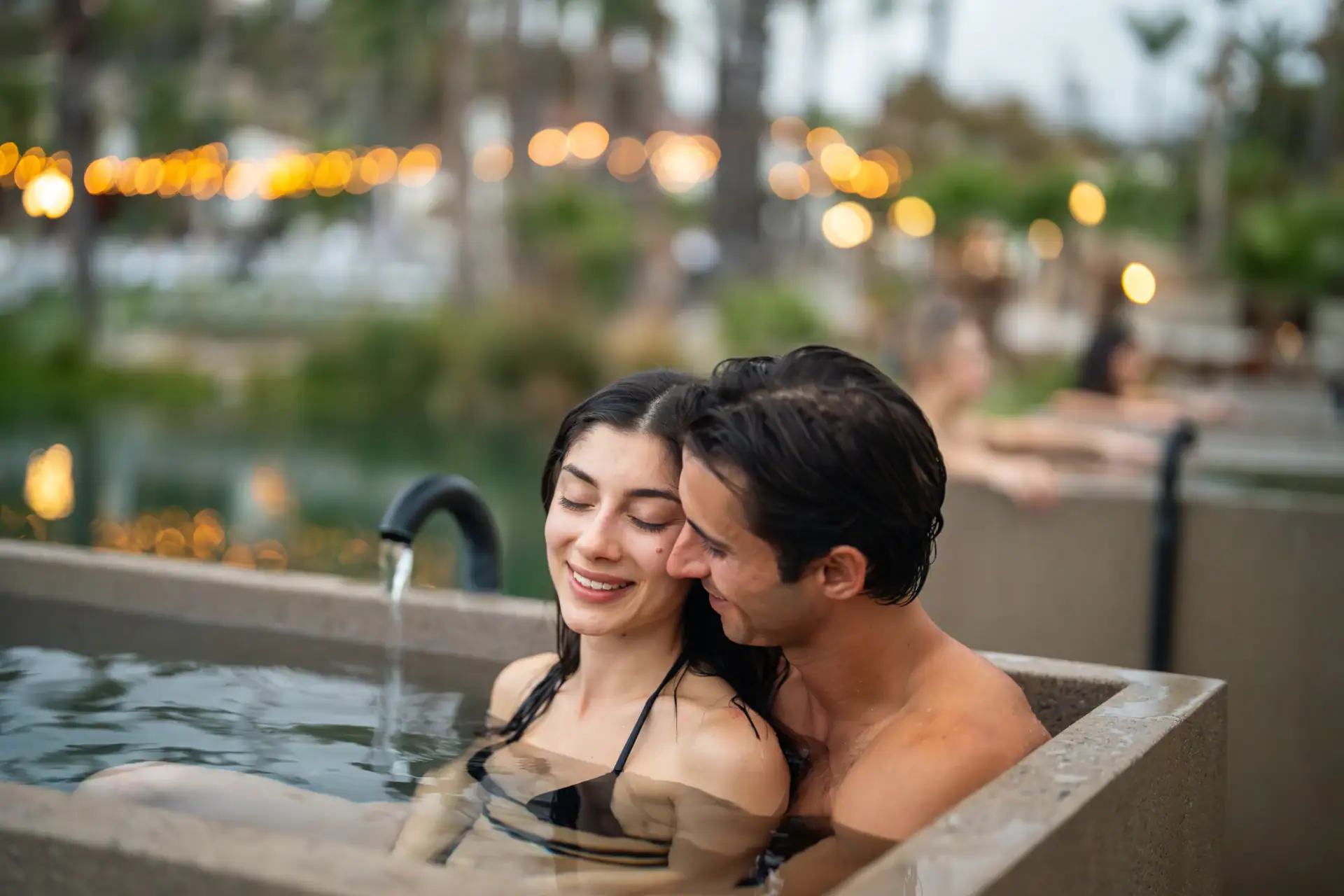 Couple enjoying a relaxing soak in outdoor hot springs at Murrieta Hot Springs.
