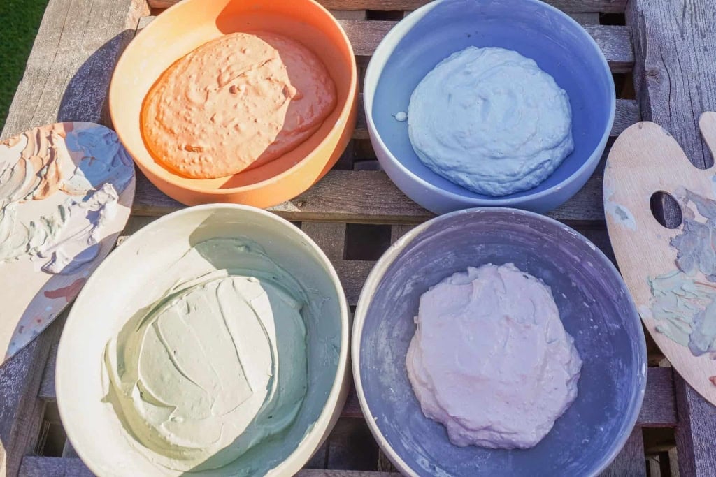 Assorted facial masks in colorful bowls for spa and wellness relaxation.