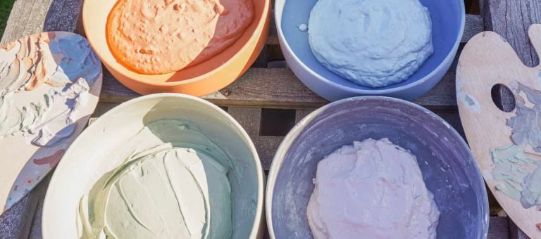 Assorted facial masks in colorful bowls for spa and wellness relaxation.