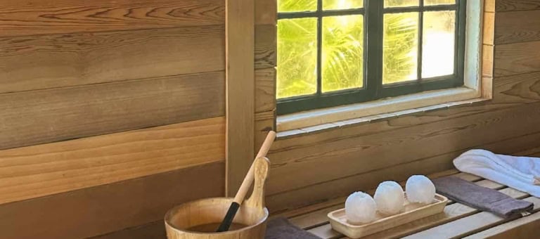 Relaxing spa area with wooden interior, towels, and sauna accessories.