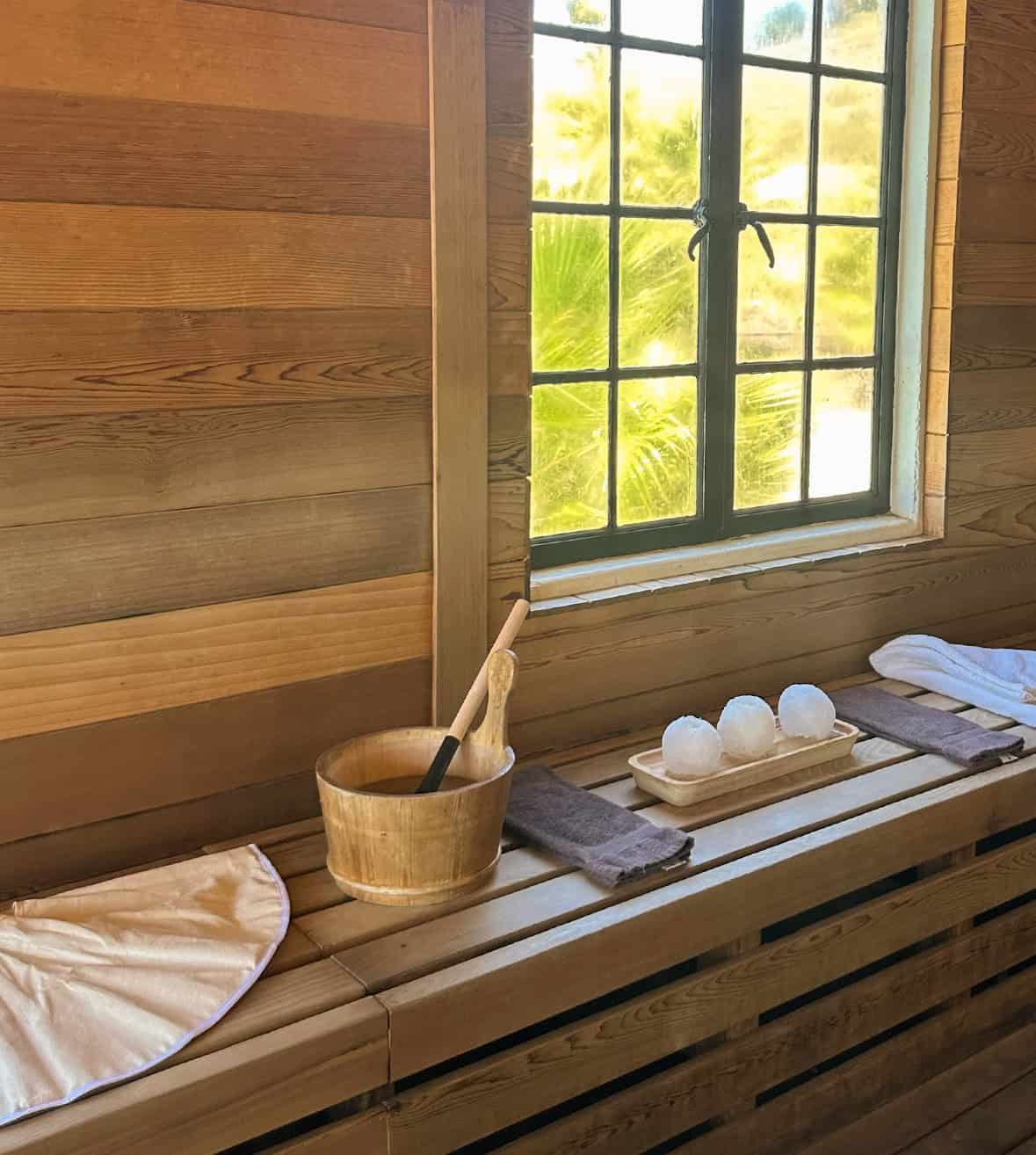 Relaxing spa area with wooden interior, towels, and sauna accessories.