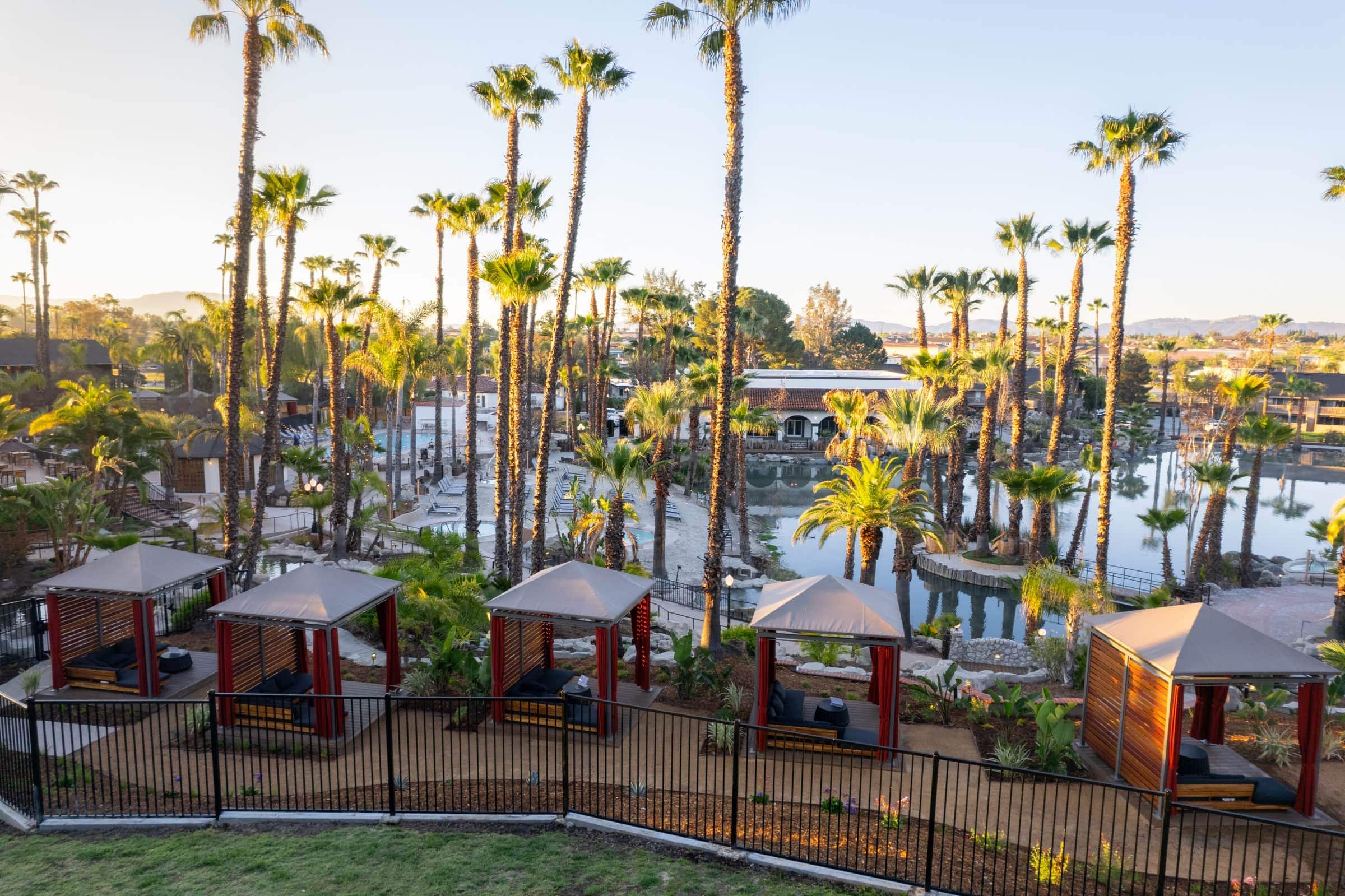 Luxury cabanas and palm trees at Murrieta Hot Springs Resort pool.
